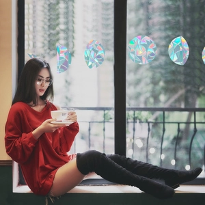 Rainbow prism window film creating colorful light effects on glass with geometric patterns