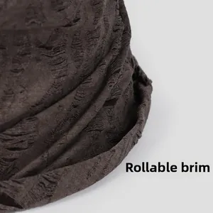 Detailed close-up of distressed cotton bucket hat showing rollable brim and torn texture