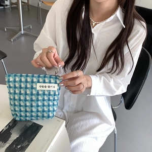 Détail de la trousse cosmétique tissée bleue et blanche avec fermeture éclair