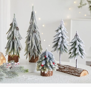Detail of mini artificial snowy Christmas trees with wooden bases and pine cones