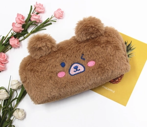 Close-up of fluffy brown bear plush pencil case with cute embroidery on white background