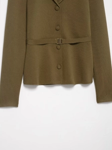 Détail du cardigan en maille vert olive avec ceinture assortie et boucle métallique