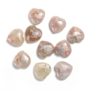Flat lay of heart-shaped natural rose quartz stones with polished marble texture