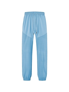 Detail of light blue joggers featuring elastic drawstring waist and textured fabric stitching