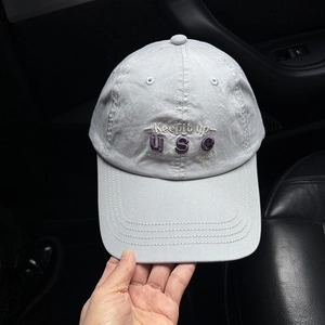 Close-up of letter embroidery on a light grey washed cotton baseball cap texture