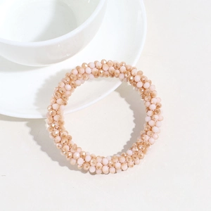 Macro detail of elegant peach pink and champagne crystal beads on a stylish hair tie