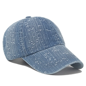 Detailed macro view of distressed light blue denim texture and frayed edges on baseball cap