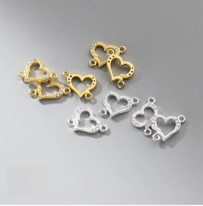 Macro detail of 925 sterling silver heart connectors with zircon inlay for DIY jewelry
