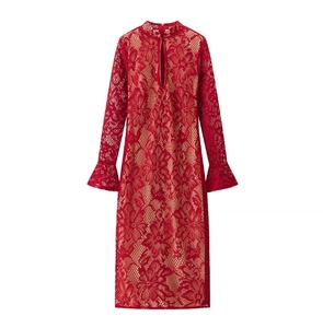 Détail de robe en dentelle rouge avec col montant ajouré et manches évasées élégantes
