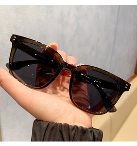 Detalle de gafas de sol cuadradas de carey con remaches plateados y lentes polarizadas