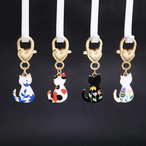Set of four cartoon cat enamel charms with heart lobster clasps on black background