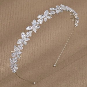 Elegant silver bridal headband with sparkling zircon flowers and leaves on beige fabric
