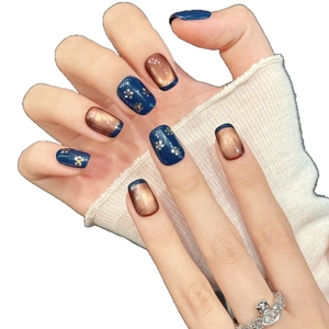 Deep blue and copper cat-eye press-on nails with sparkling flower patterns and glitter