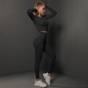 Detail of black seamless yoga set with crop top and high-waisted peach leggings