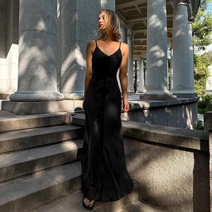 Vue détaillée d'une robe longue élégante en satin noir avec col en V devant des colonnes