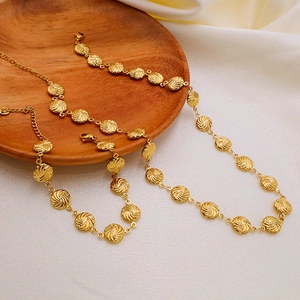 Golden unisex French style jewelry set with spiral round charms on satin and wood background