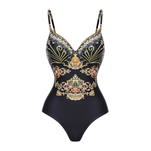Detail of ruffle black swimsuit with golden baroque emblem and gemstone print