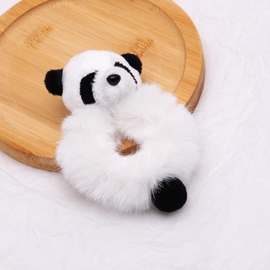 Gros plan d'un chouchou panda en peluche avec texture douce sur plateau en bois
