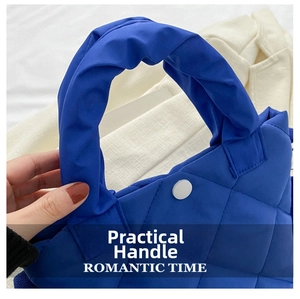 Detailed view of royal blue quilted nylon handbag with comfortable padded twisted handle