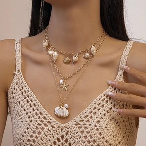 Détail de collier multicouche avec pendentifs étoile de mer, coquillage et perles