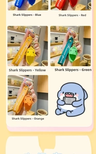 Close-up of cute shark slipper keychain with silicone wrist strap and golden buckle