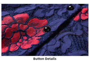 Detail of vintage black buttons on navy blue lace fabric with red floral embroidery