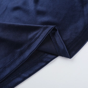 Détail de la texture lisse du tissu bleu marine et de la couture précise de l'ourlet de la robe