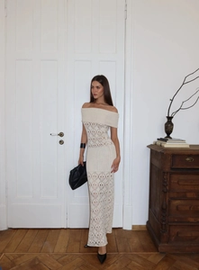 Close-up of diamond hollow knit pattern and off-shoulder detail on off-white maxi dress