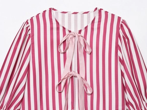 Detail of pink and white striped top featuring a bow tie neckline and cotton-linen texture