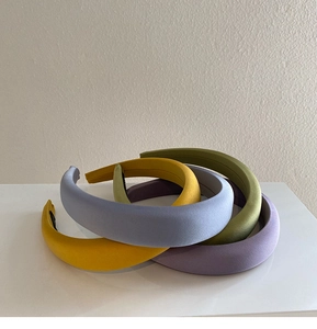 Detailed view of matte wide headbands in yellow, light blue, olive green and purple colors