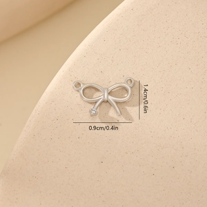 Close-up of silver bow pendant with zircon stone showing dimensions of 1.4cm x 0.9cm