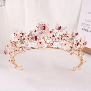 Detailed close-up of golden bridal crown with red crystals and white flowers