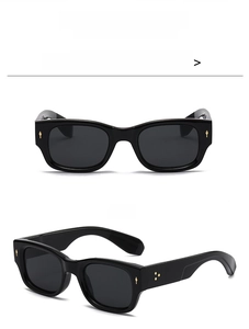 Macro detail of rectangle sunglasses frame with metallic arrow rivets and black finish