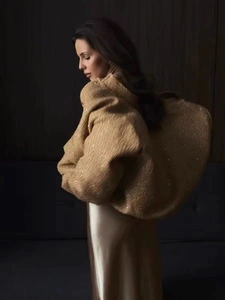 Detailed view of gold sequined jacket with heavy texture and satin skirt luxury finish