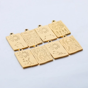 Macro view of eight gold square zodiac pendants with engraved symbols and names