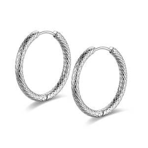 Macro shot of silver titanium steel hoop earrings with textured diamond pattern finish