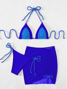 Flat lay of royal blue three-piece bikini set with side-tie skirt and braided rope details