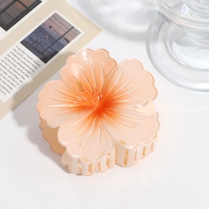 Macro detail of a gradient peach flower hair claw clip with a glossy acrylic finish