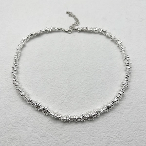 Detailed macro view of irregular silver shards necklace with adjustable lobster clasp