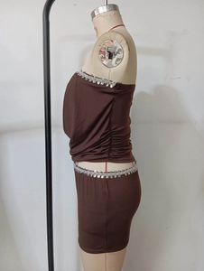 Détail de paillettes argentées sur la taille d'un ensemble jupe et haut marron ajusté