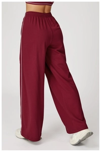 Détail du pantalon de sport bordeaux à jambes larges avec bandes blanches et taille haute