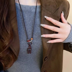 Detail of a vintage long necklace featuring a resin bear pendant on a dark cord