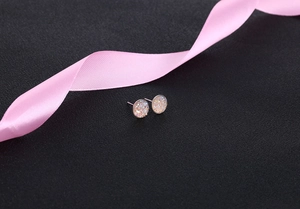 Detailed macro view of S925 silver iridescent round crystal stud earrings on dark background