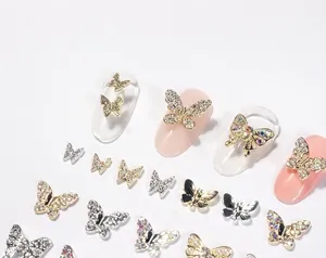 Detail showing 3D butterfly nail charms with micro-pave rhinestones and gold plating