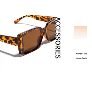 Detail of square tortoiseshell sunglasses featuring deep brown lenses and a retro frame