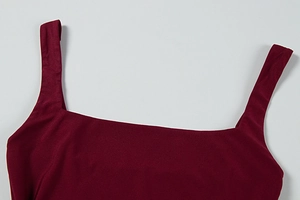 Detailed close-up of burgundy square neck dress with wide shoulder straps and flat stitching