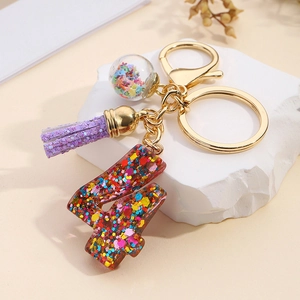 Detail of resin number 4 keychain with purple glitter tassel and a glass star charm