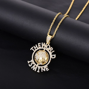 Détail du pendentif planète dorée avec strass et gravure The World Is Mine