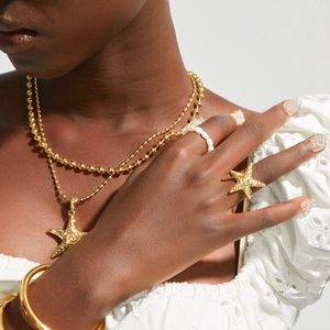 Set di collana con ciondolo a stella marina dorata e anelli per un look estivo da mare