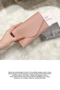 Close-up of light pink faux leather passport wallet with lychee grain and curved flap